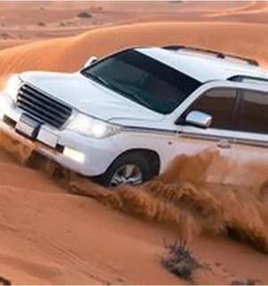 a truck driving through the sand in the desert