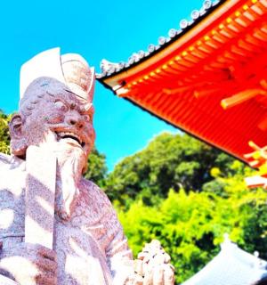 a statue of a man standing next to a red umbrella