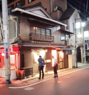 two people standing in front of a building on a street