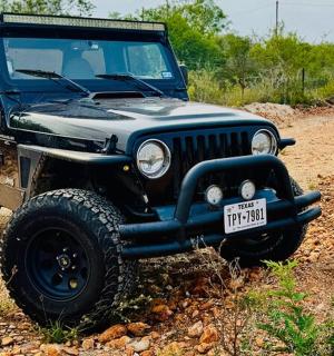 a black jeep parked on a dirt road