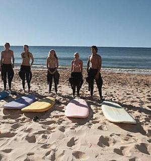 a group of people standing on a beach with surfboards