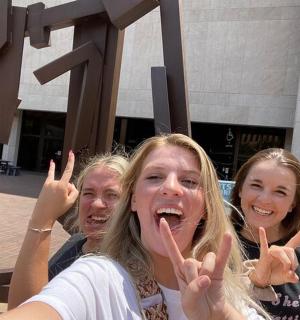 tři dívky dávají prsty znamení míru