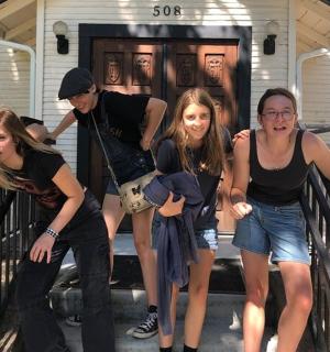 skupina lidí stojících na schodech domu