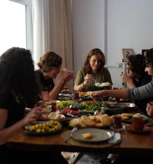 a group of women sitting around a table eating food