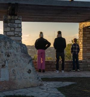 skupina lidí stojících na kamenné zdi