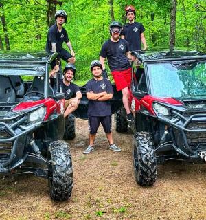 a group of people standing next to two atvs
