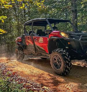 a red atv driving down a dirt road