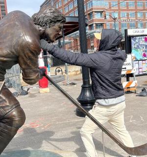 a woman hugging a statue of a baseball player