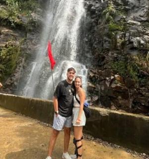 一名男子和一名女子站在瀑布前