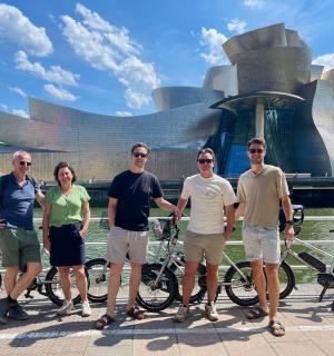 skupina lidí stojících před budovou s koly