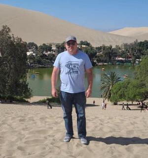 一名男子站在海滩上的沙子上