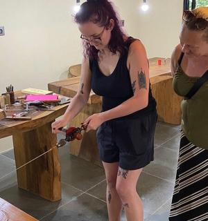 two women standing next to a table holding a string