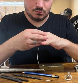 a man sitting at a table with his hands together