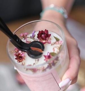 a person holding a glass with a pair of scissors