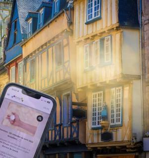 a person holding a cell phone in front of a building