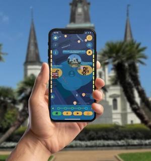 一只手拿着手机站在建筑物前