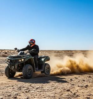一名男子在沙漠中骑着四轮摩托车