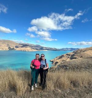 两个人站在水边的山上