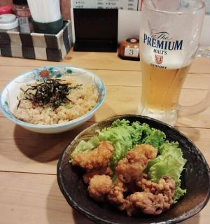 a table with a plate of food and a glass of beer