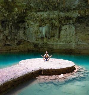 a person sitting on a rock in a pool of water
