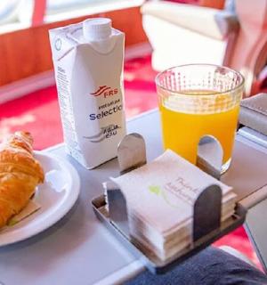 一个托盘,上面放着一盘食物和一杯橙汁