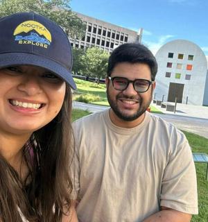 a man and a woman posing in front of a building
