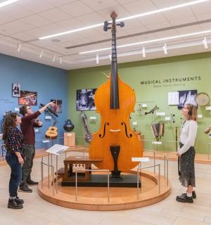 一群人在博物馆里观看一把小提琴。