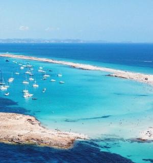 an aerial view of a beach with boats in the water