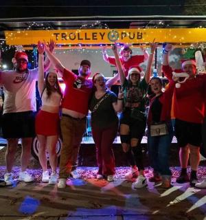 a group of people dressed in christmas costumes standing in front of a bus