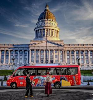 一辆红色巴士停在一座圆顶建筑前。