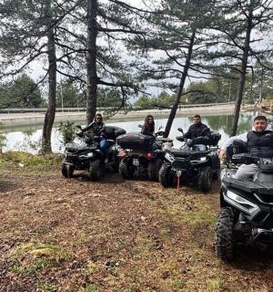 一群人骑着停在河边的四轮摩托车