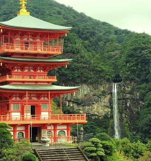 a large red building with a tower with a waterfall