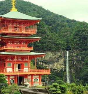 a large red building with a tower next to a waterfall