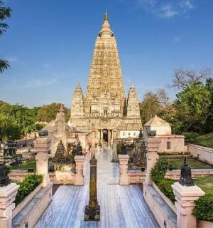 a temple in a park with a tower in the background