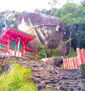 a red building next to a large rock