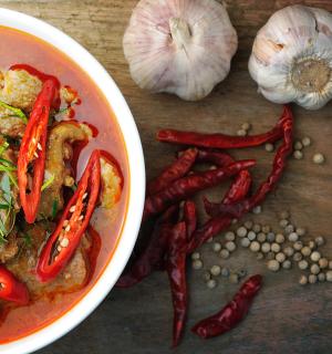 a bowl of food with red peppers and some garlic