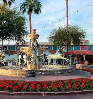 fontána uprostřed ulice s červenými květy