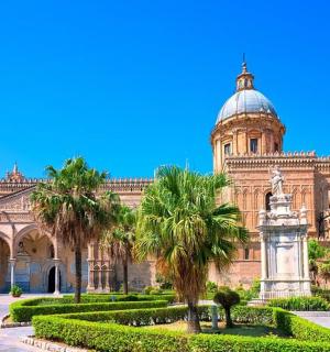 budova se sochou a palmami před ní