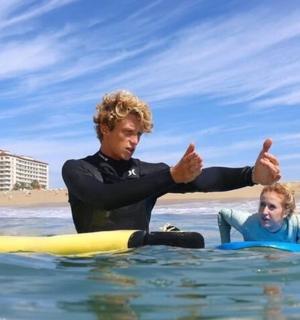 muž a dítě na surfu ve vodě