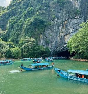 three boats in a river near a mountain