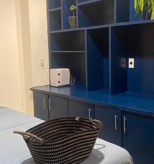 спальня з синіми шафами та плетеним кошиком