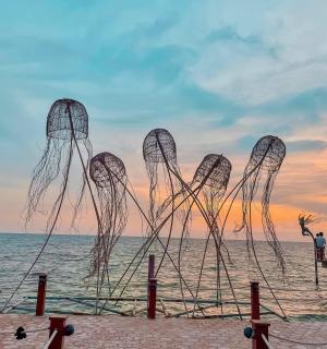a sculpture on the beach at sunset