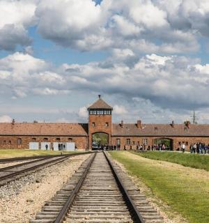 火车轨道旁有一座带有钟楼的砖砌建筑