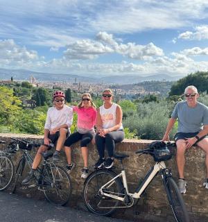 a group of people sitting on a wall with bikes