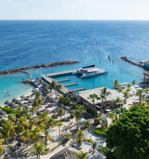 an aerial view of a beach with a boat in the water