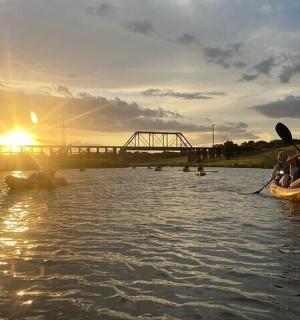 dva lidé v šlapadle na řece s mostem