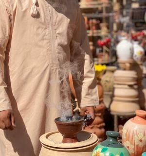 a man in a pottery shop with a potter working on a vase
