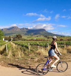 一名女子骑着自行车沿着土路行驶