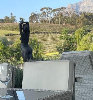 阳台上摆着一张桌子,桌上放着酒杯和一尊雕像。