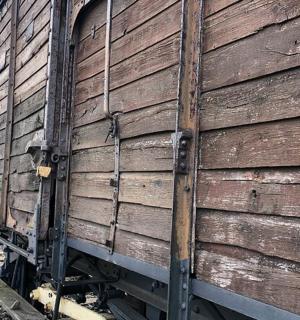 一辆木制火车车厢停在铁轨上